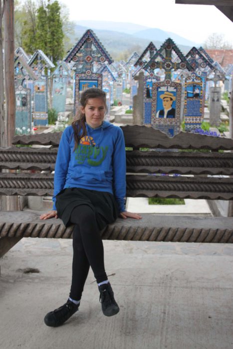 Girl in blue hoodie sitting on the cemetery.