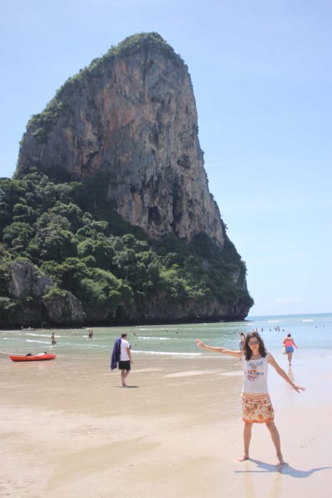 Girl on the beach in Krabi, big rock in the background.