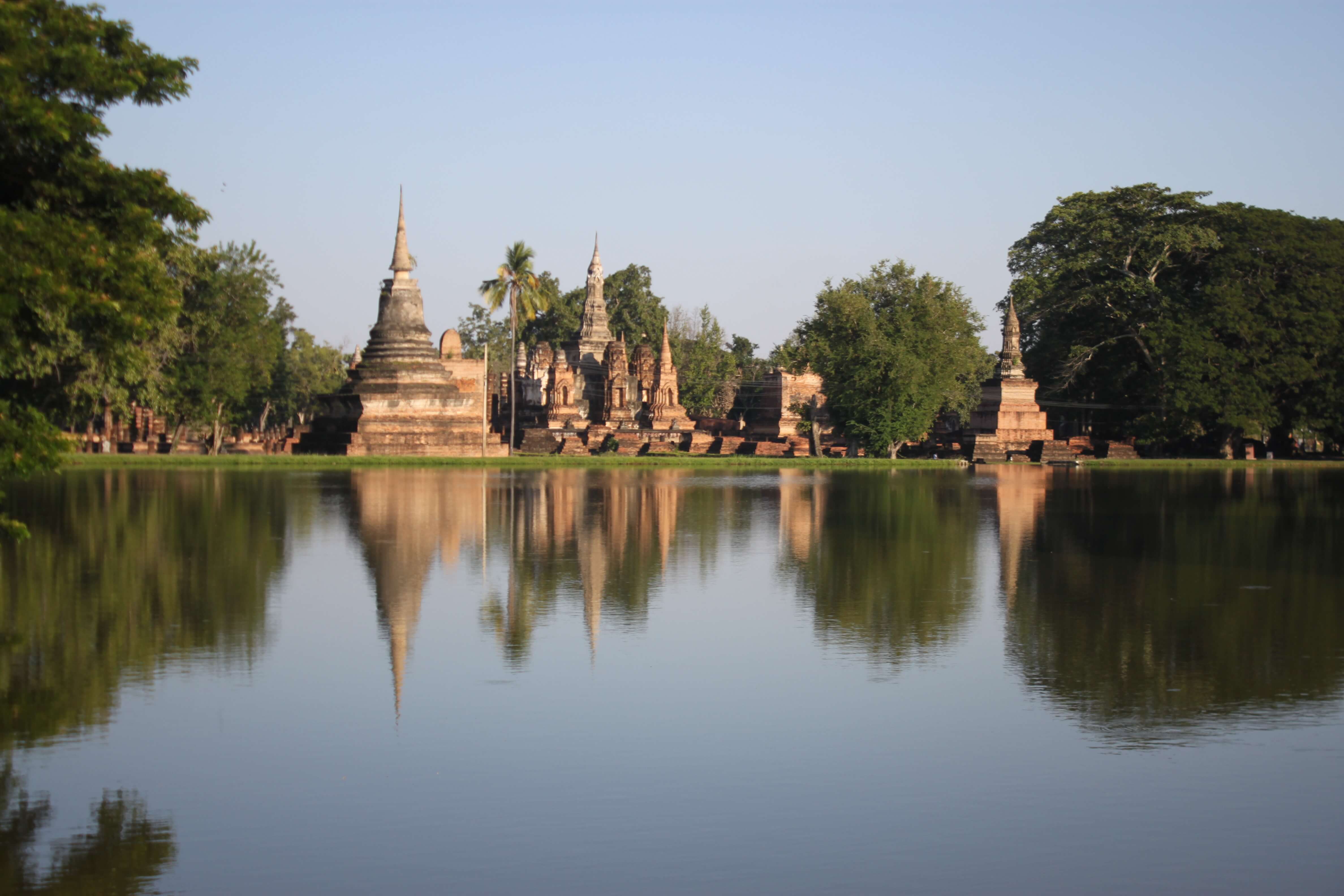 Temples of Sukhothai and their reflection in the water. Going by bicycle around Sukhotai.