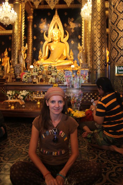 Buddha in Phitsanulok Temple, a girl having selfie with Buddha. Golden statue of Phitsanulok Buddha.