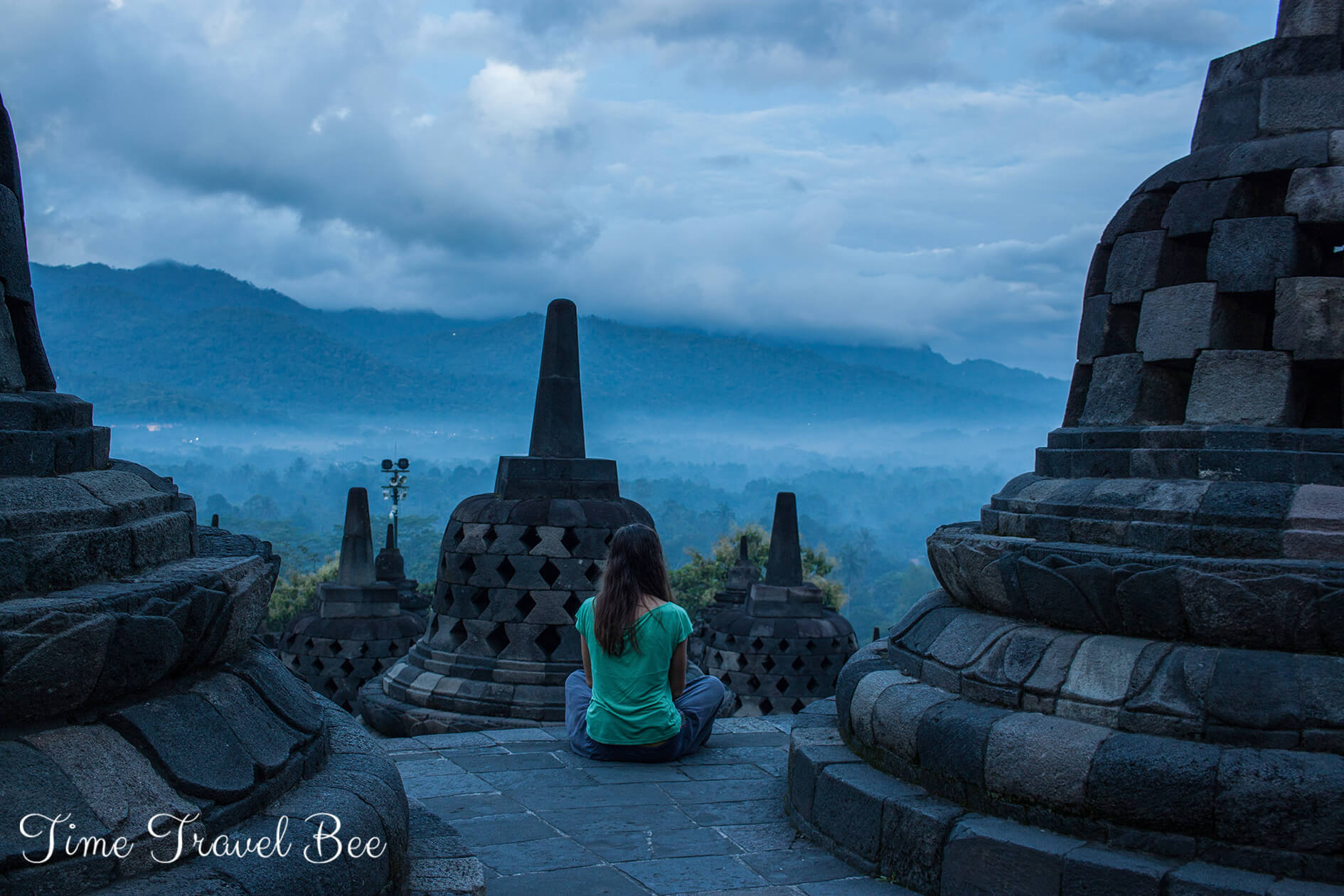 Borobodur Sunrise Tour Girl meditating in Borobodur temple during sunrise.