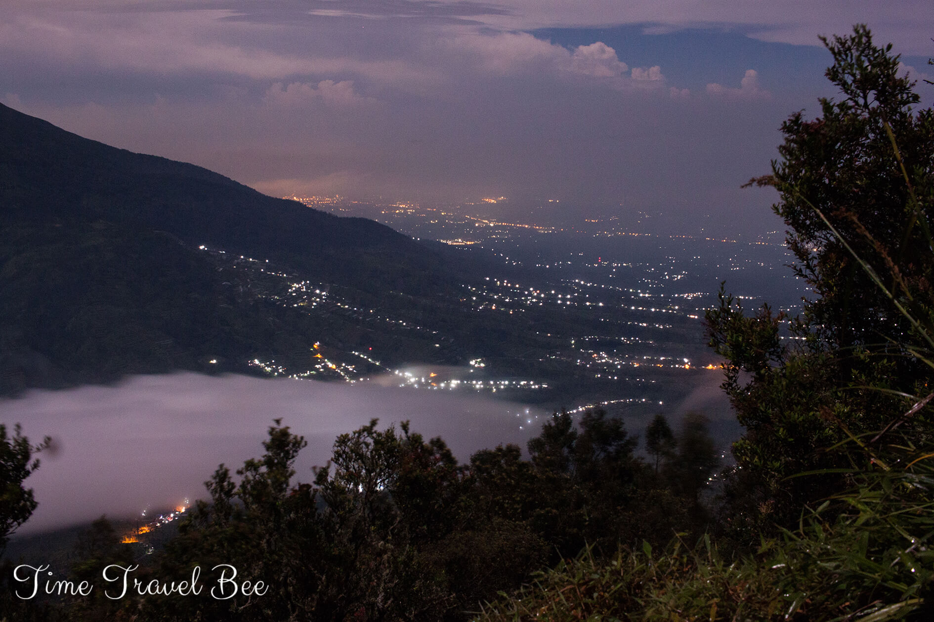 Chmury pod stopami i wspinaczka na wschód słońca na wulkanie na Jawie. Indonezja.