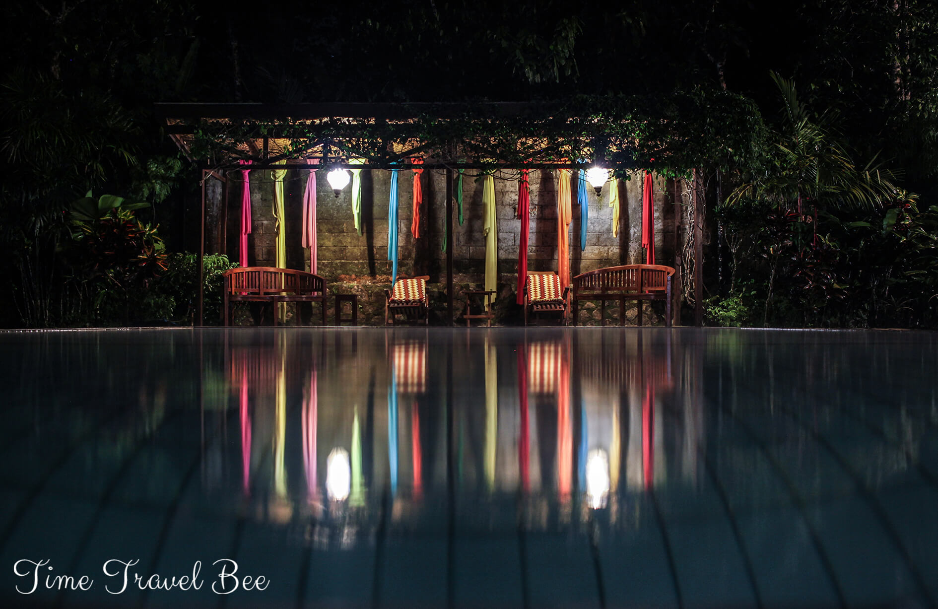 Basen i krzesełka z ozdobami, odbicie kolorów w wodzie.