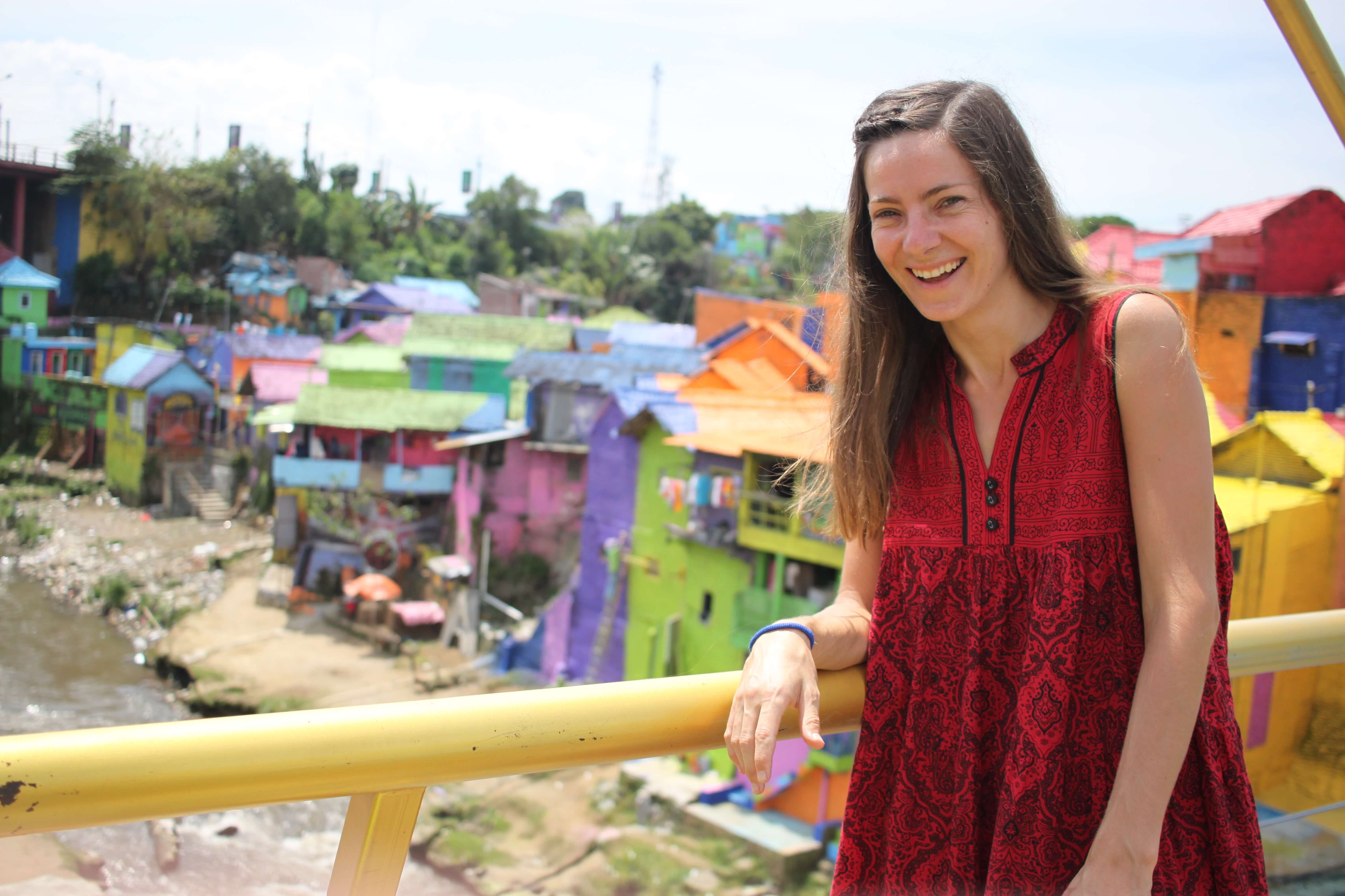 Colorful town, smiling girl in a red dress.