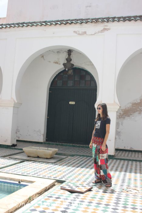 Szkoła islamska w Algierii. Dziewczyna w kolorowych spodniach w łaty, dziedziniec szkoły islamskiej, fontanna, arkady, drzwi, mozaika.