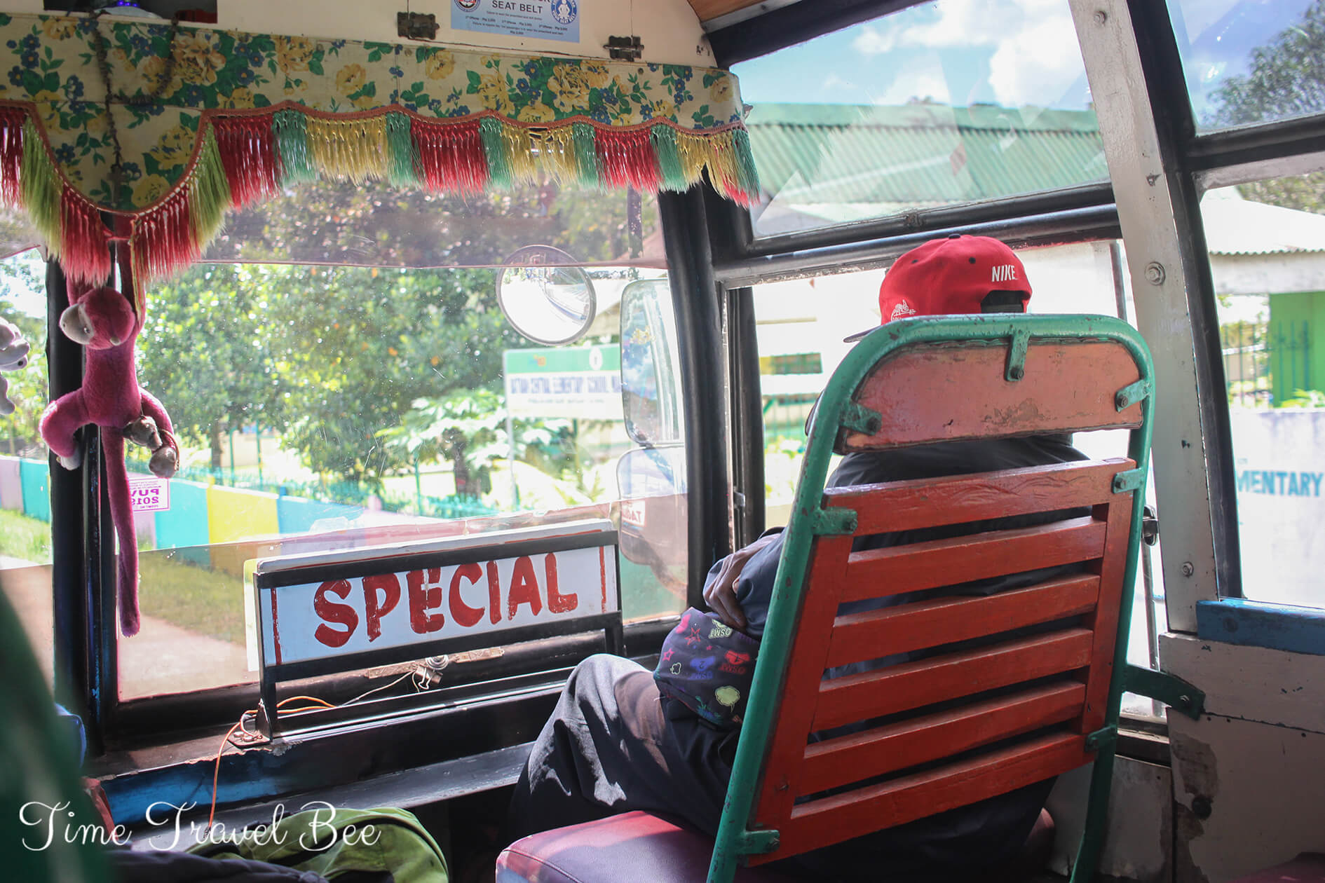Traveling around Bohol by public transport. Man sitting on a special sit in the old bus.
