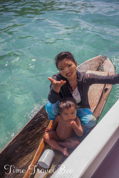 Morscy Cyganie żebrzą o pieniądze w drewnianej łodzi.