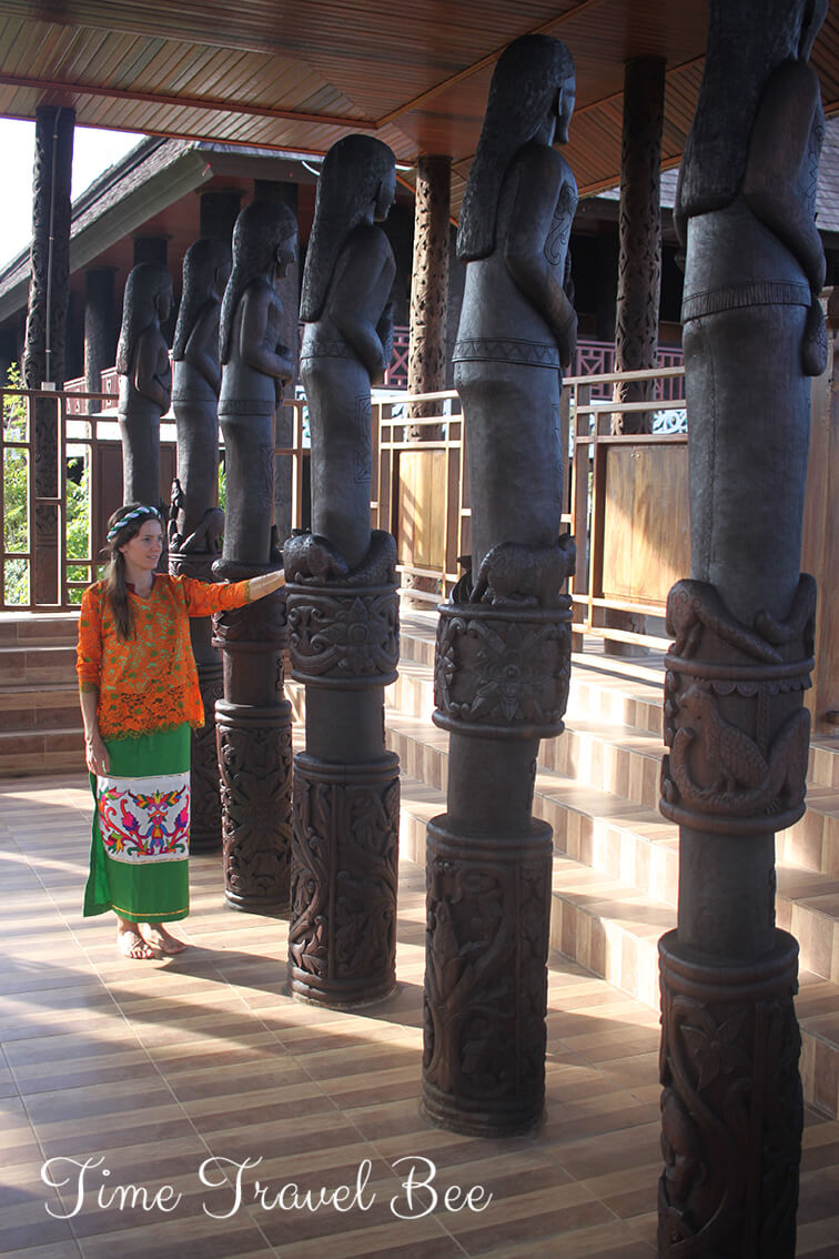 Drewniane stupy muzeum w Indonezji, dziewczyna w stroju Dajaków.