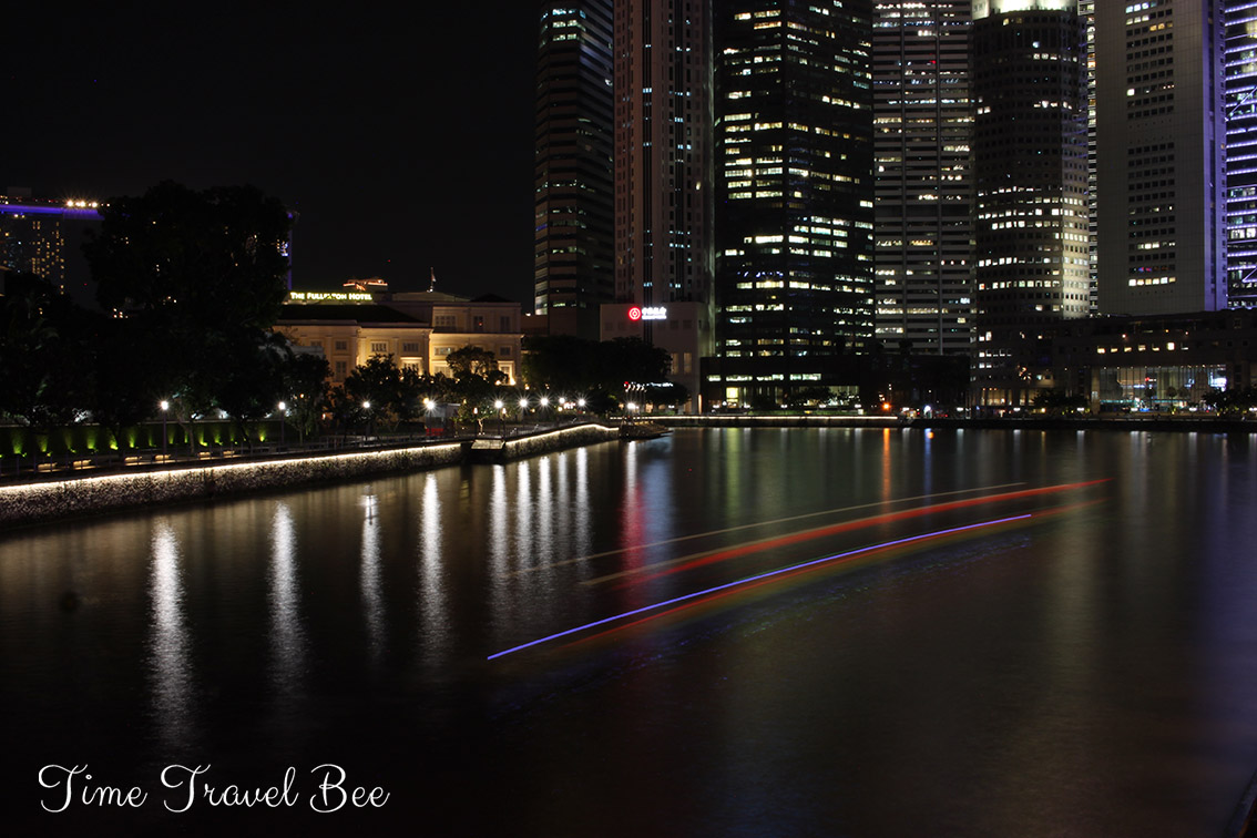 Fotografia nocna w dużym mieście. Światła budynków i przepływającej łodzi. Długie naświetlanie.